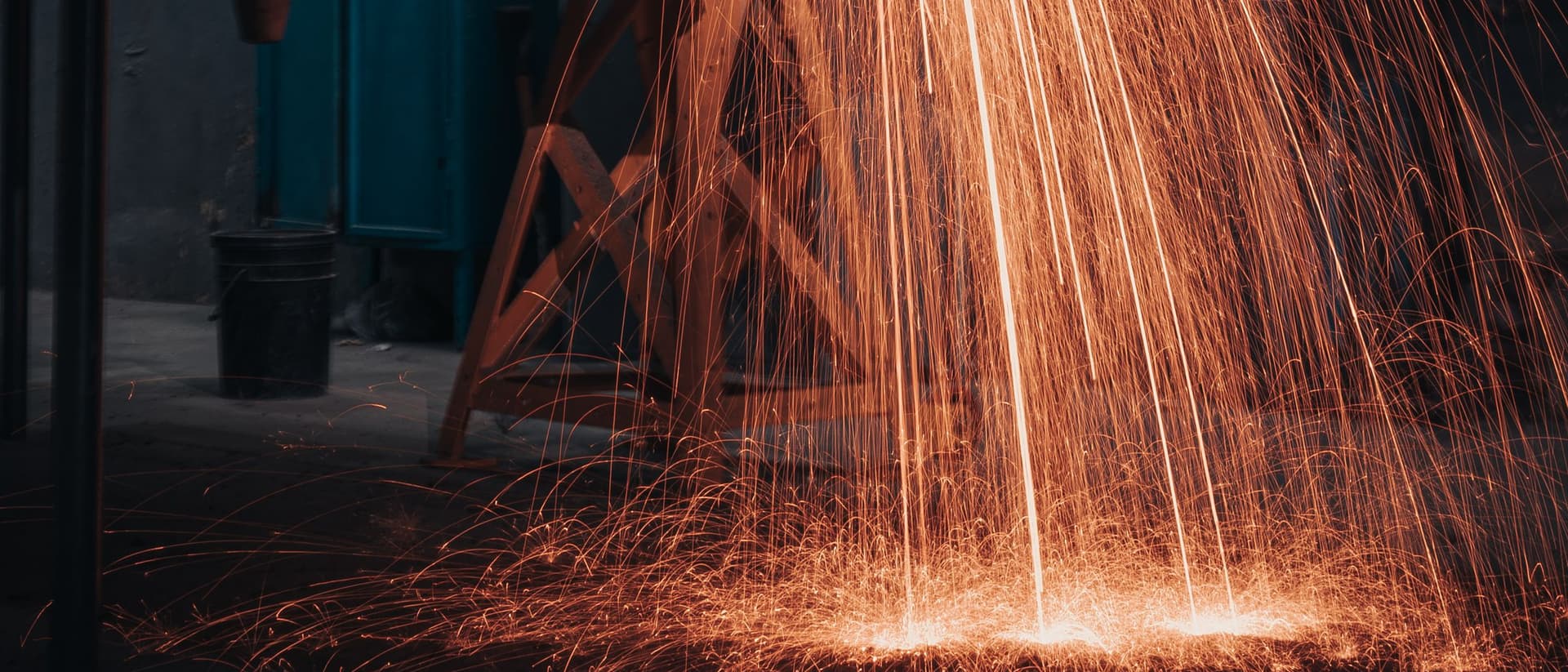 Cascata de faíscas iluminando o interior escuro de uma oficina industrial