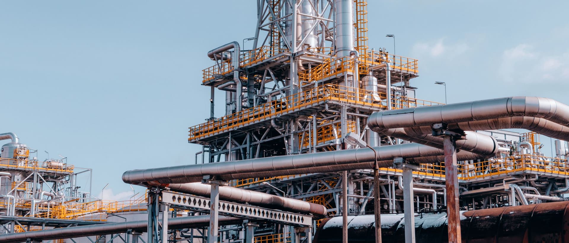 Estrutura de tubulações e torres de uma planta petroquímica vista de baixo